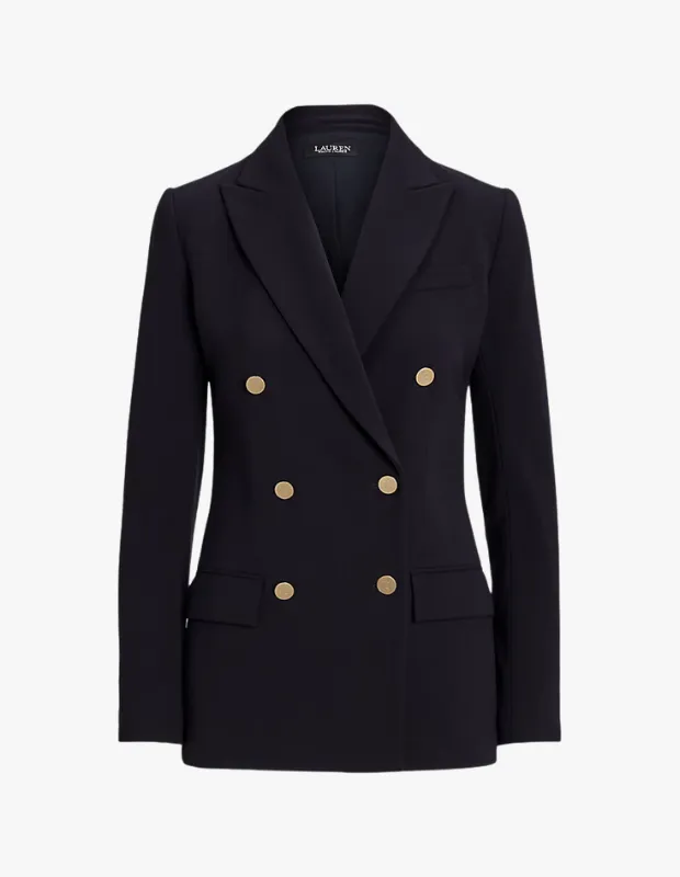 Beyaz bir arka plan üzerinde dikkat çekici bir şekilde konumlandırılmış, altın renkli altı düğmesi ve kruvaze kesimiyle preppy stil blazer kombinleri için ideal olan, şık ve klasik lacivert bir blazer ceket.