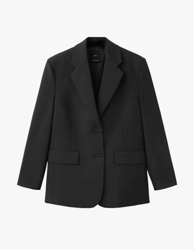 Düz beyaz bir arka plan üzerinde sergilenen, iki siyah düğmeli, geniş sivri yakalı ve iki kapaklı cepli, şık ve modern bir tasarıma sahip siyah blazer ceket, farklı blazer kombinleri oluşturmak için ideal bir seçenek sunuyor.