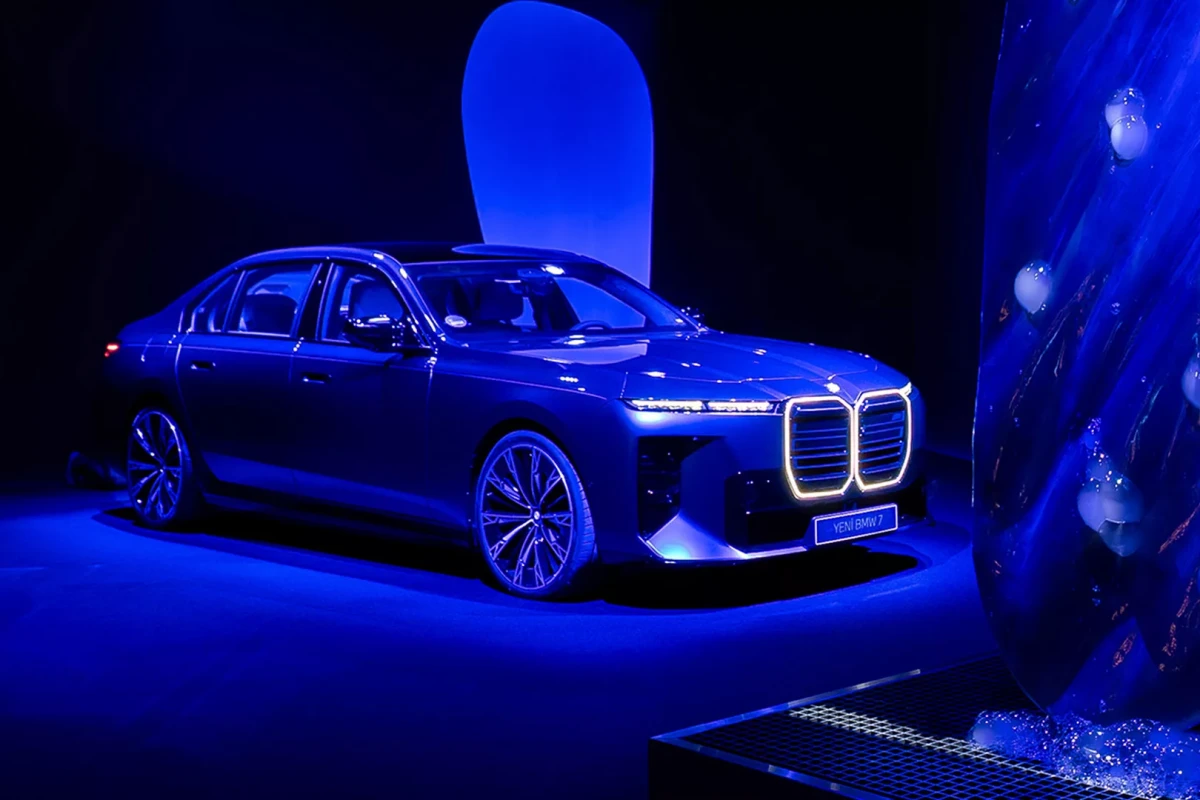 Parlak bir ışıklandırma altında sergilenen modern BMW 7 Serisi otomobil, Azusa Murakami ve Alexander Groves'un ikonik canlı çiçek motifleriyle donatılmış bir tasarımla sanat ve teknolojinin benzersiz bir simbiyozunu çarpıcı bir şekilde yansıtıyor.