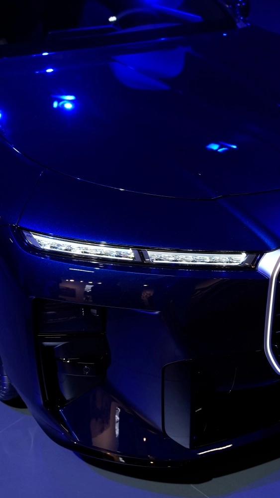 Bir BMW Murakami Symbiosis projesi kapsamında, beyaz bir BMW 7 Serisi otomobilin ön çamurluğunda Azusa Murakami ve Alexander Groves tarafından aracın yüzeyine mükemmel bir şekilde entegre edilmiş sanatsal ve dinamik bir tasarım detayı yakından görülüyor.