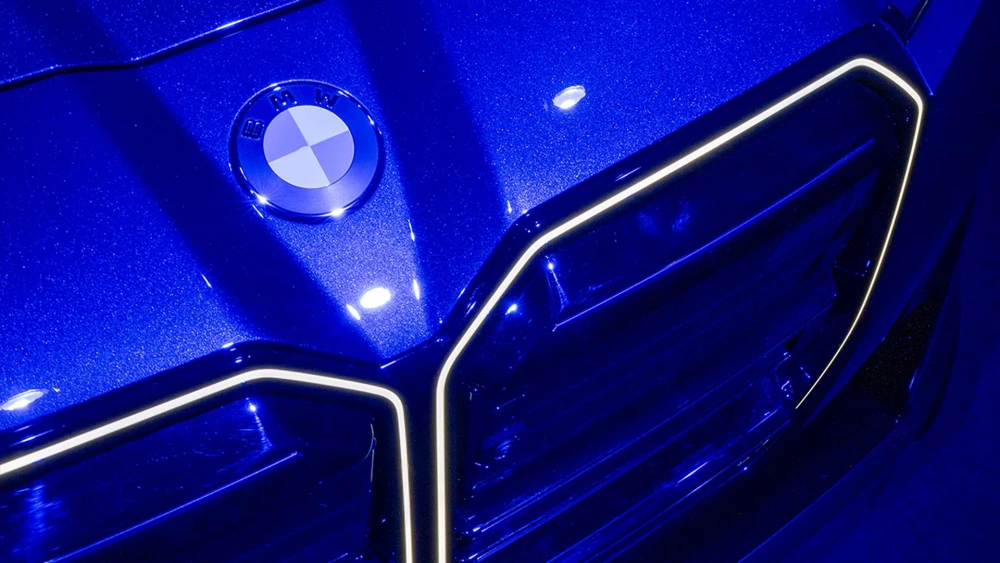 Modern bir BMW 7 Serisi otomobil, arkasında Azusa Murakami ve Alexander Groves'un canlı renkler ve özgün çiçek motifleriyle dolu ikonik sanat eserinin bulunduğu iç mekanda, marka ve sanatçı arasındaki çarpıcı bir simbiyozu gözler önüne seriyor.
