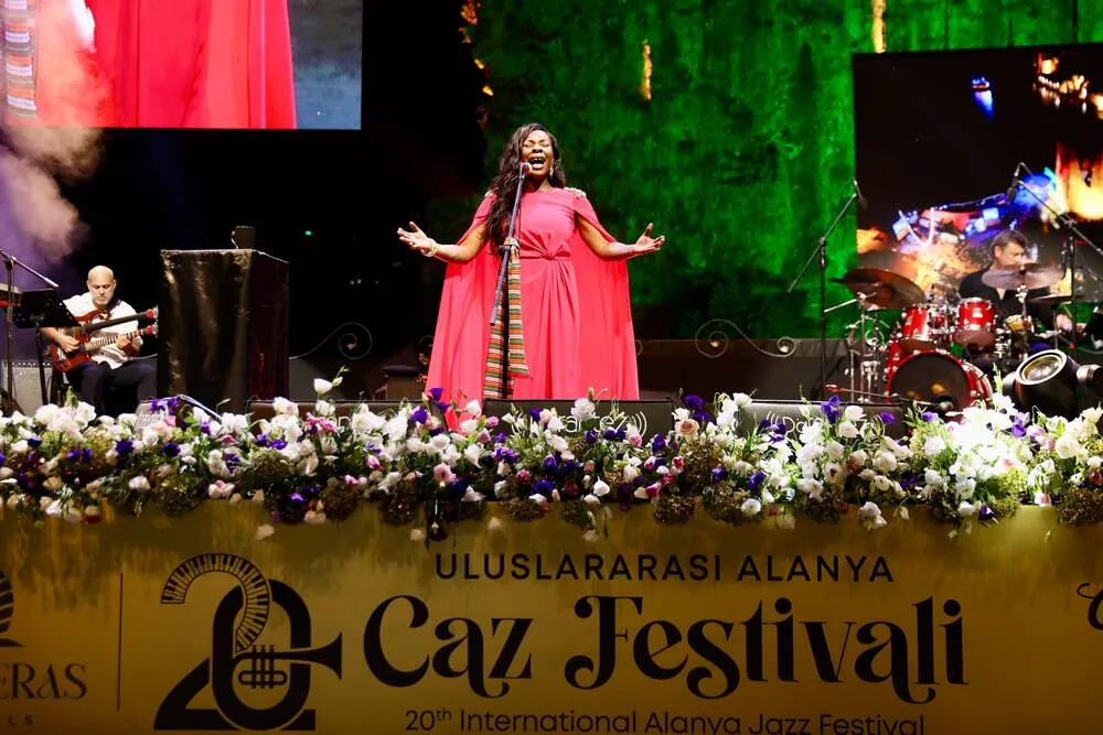 Caz festivali için verilen bir röportaj anında çekilen bu karede, Buika koyu renk kıvırcık saçları yukarı toplanmış, üzerinde geleneksel esintili, canlı desenlere sahip bir bluz ve büyük küpelerle, sakin ve düşünceli bir ifadeyle hafifçe yana bakıyor.