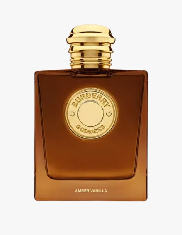 Dikdörtgen, kehribar rengi, altın renkli oluklu kapağa sahip bir Burberry Goddess Amber Vanilla parfüm şişesi, ortasında markanın logosu ve altında Amber Vanilla yazısı ile sade bir arka planda sergileniyor.
