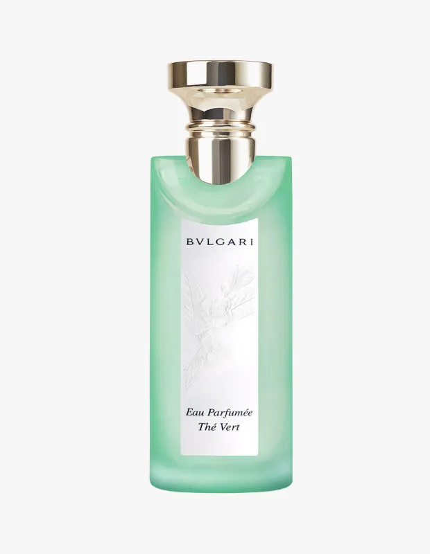 Bvlgari Eau Parfumée au Thé Vert parfümünün, şeffaf ve hafif yeşil tonlarındaki uzun, ince cam şişesi, koyu yeşil kapağı ve altın rengi Bvlgari yazısıyla zarif bir zeminde dik bir şekilde sergileniyor, yeşil çay temasını anımsatan taze ve sofistike bir atmosfer sunuyor.