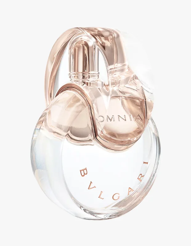 Bvlgari Omnia Crystalline parfümünün ikonik, birbirine geçmiş halka benzeri şeffaf cam şişesi, kristalin adını yansıtan berrak ve ışıltılı bir tasarımla ışıkta parlayarak koleksiyonun zarif bir üyesini gözler önüne seriyor.