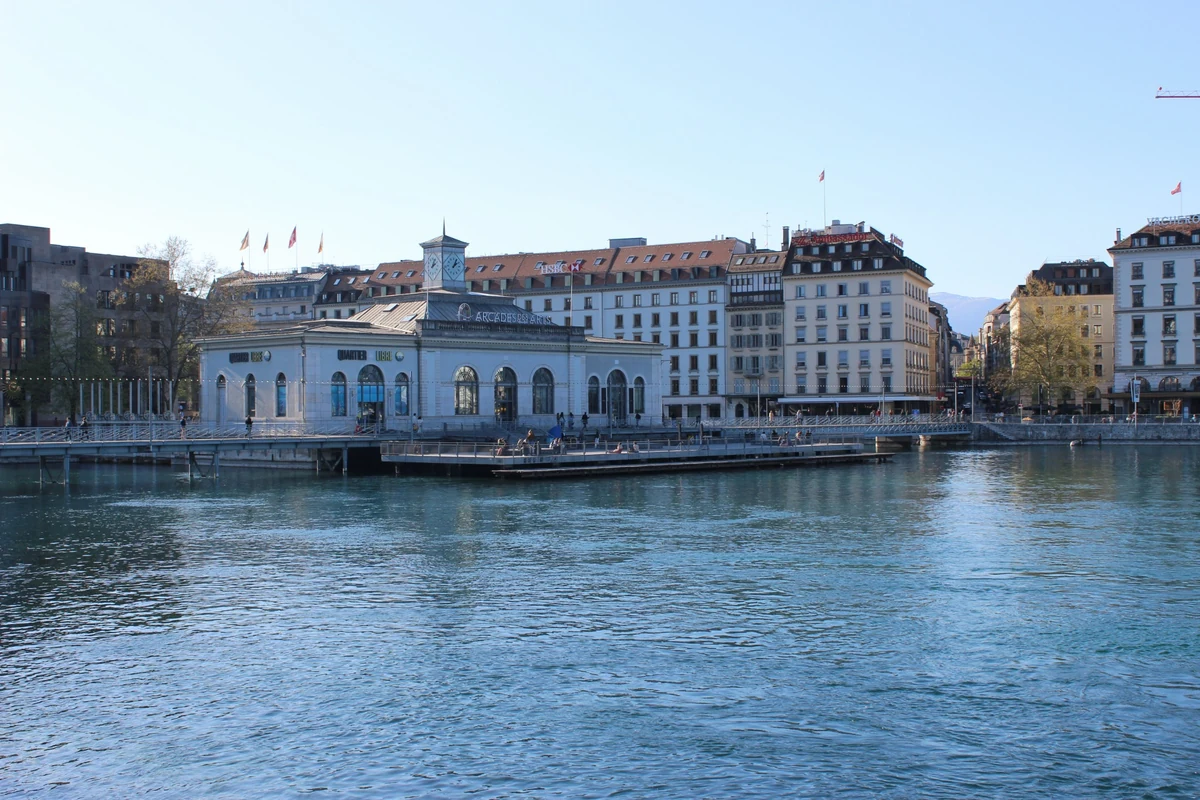 Güneşli bir Cenevre gününde, Rhône Nehri üzerinde yer alan, Arcades des Arts ve Quartier Libre'ye ev sahipliği yapan Pont de la Machine binası, kemerli yapısı ve saat kulesiyle şehrin görülesi yerlerinden birini oluşturuyor.