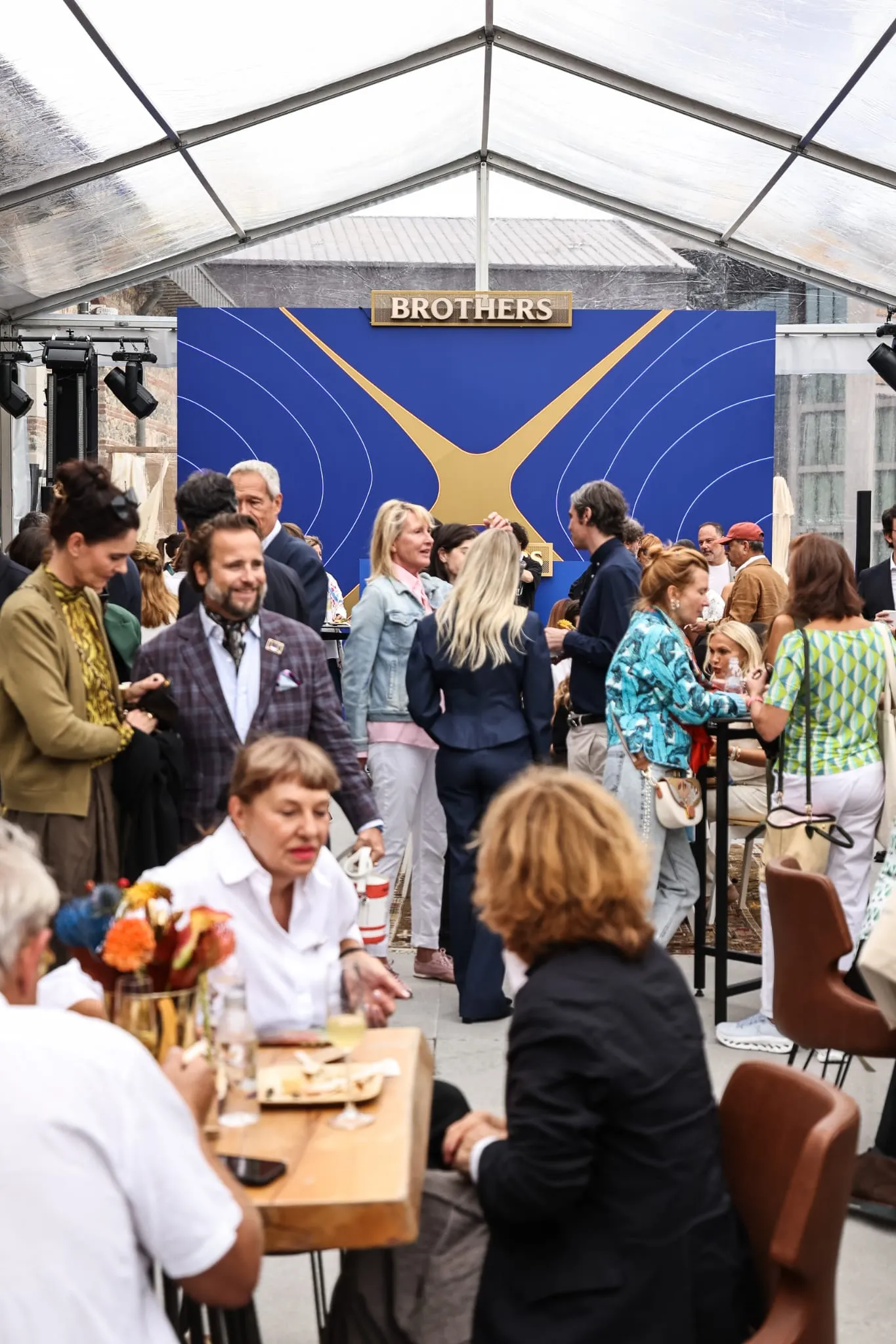 Contemporary Istanbul'un 21. edisyonundaki House of Brothers Lounge'da, Seçkin Pirim'in birbirini tamamlayan dört formdan oluşan Blend adlı heykeli üzerinde oturan ve sanat sohbetleri eden ziyaretçiler, Brothers'ın Birbirimiz İçin temasıyla etkileşim halinde.