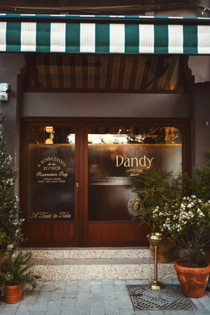 Kuruçeşme'de yer alan zarif yeni mekân Dandy'nin koyu ahşap panellerle çevrili, loş ışıklı modern iç mekânında, şık misafirler geniş bir barın etrafında toplanmış, imza kokteyller ve özel lezzet deneyimleriyle keyifli sohbetler ediyor.