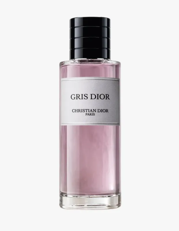 Christian Dior markasına ait, üzerinde GRIS DIOR yazan gri etiketli, içinde açık lila rengi parfüm sıvısı bulunan zarif tasarımlı, silindirik, siyah kapaklı bir parfüm şişesi dikey olarak beyaz bir arka plan önünde duruyor.