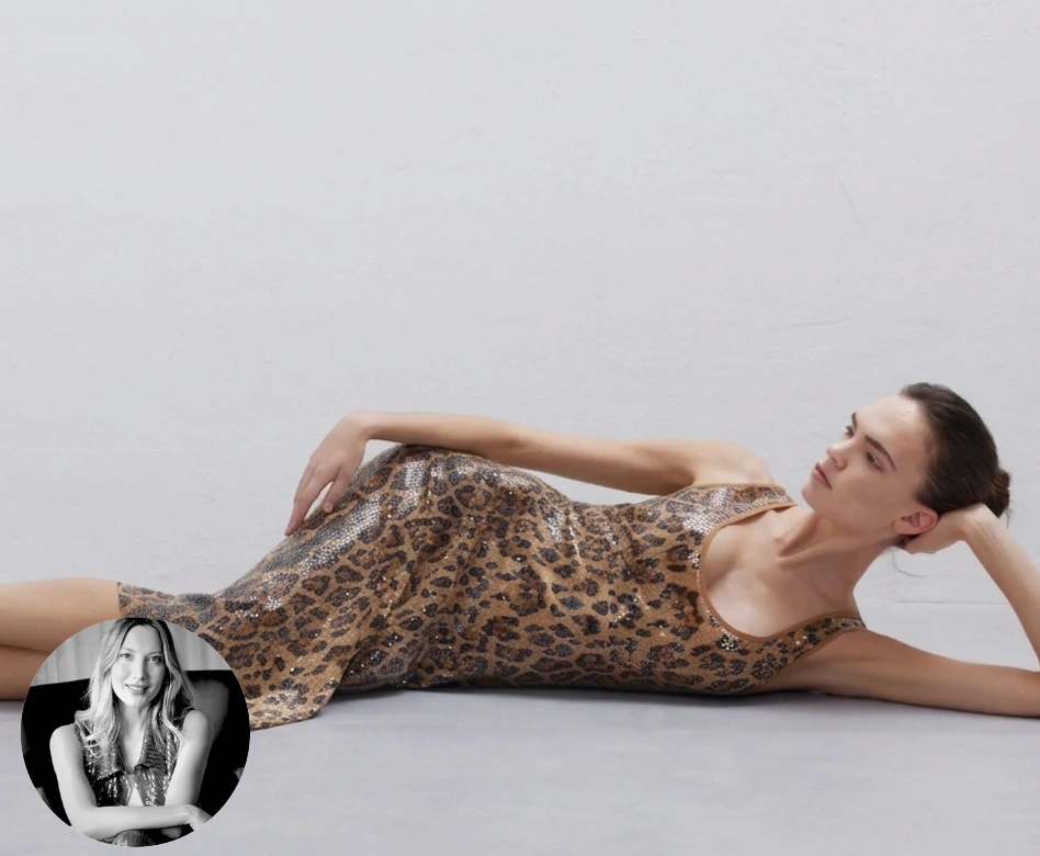 Pul işlemeli leopar desenli mini elbise giyen bir modelin zarif moda pozu, açık renkli bir stüdyo zemininde yan yatarken, sol altta Esen Sağıroğlu'nun siyah beyaz dairesel portresiyle tamamlanıyor.
