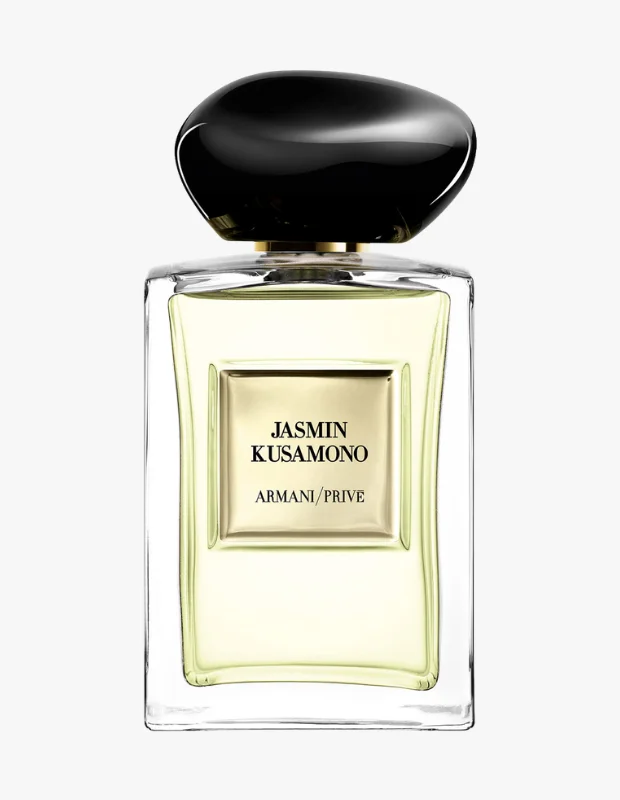 Siyah, pürüzsüz bir zemin üzerinde zarif bir şekilde konumlandırılmış, dikdörtgen formlu, koyu renk camdan yapılmış Giorgio Armani Jasmin Kusamono parfüm şişesi, üzerindeki aydınlık kapağı ve sade etiketiyle bu özel koleksiyonun özünü yansıtmaktadır.