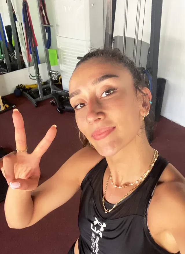 Voleybolcu Hande Baladin, spor salonunda çektiği samimi selfie'de, terli yüzüyle gülümseyerek sol eliyle barış işareti yapıyor; bu fotoğraf, onun antrenmanlarına ve kişisel anlarına dair ilginç bilgilerden birini gözler önüne seriyor.