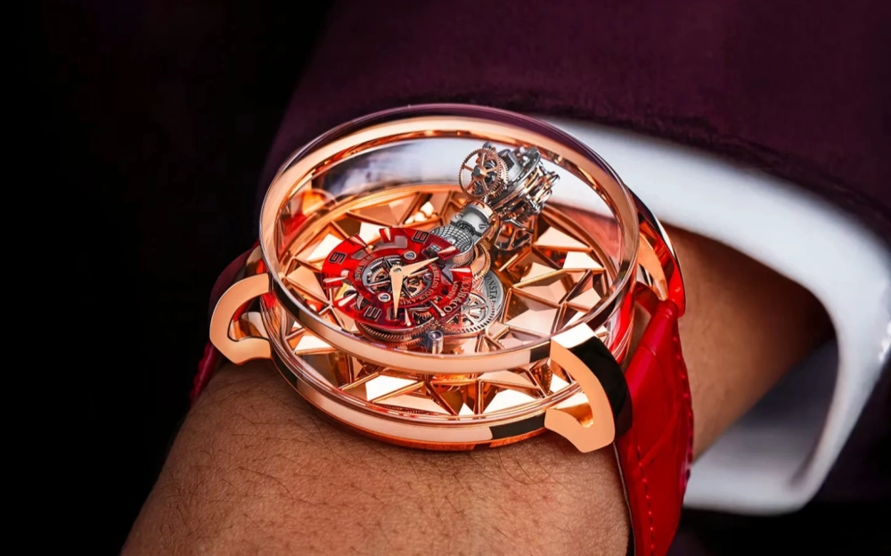 Jacob & Co. Astronomia modelinin rose altın kasasına yerleştirilmiş, şeffaf kadranından karmaşık bir şekilde görünen dört eksenli tourbillon mekanizmasıyla adeta bir mikro-kozmosu andıran, detaylı ve yenilikçi bir lüks kol saati.