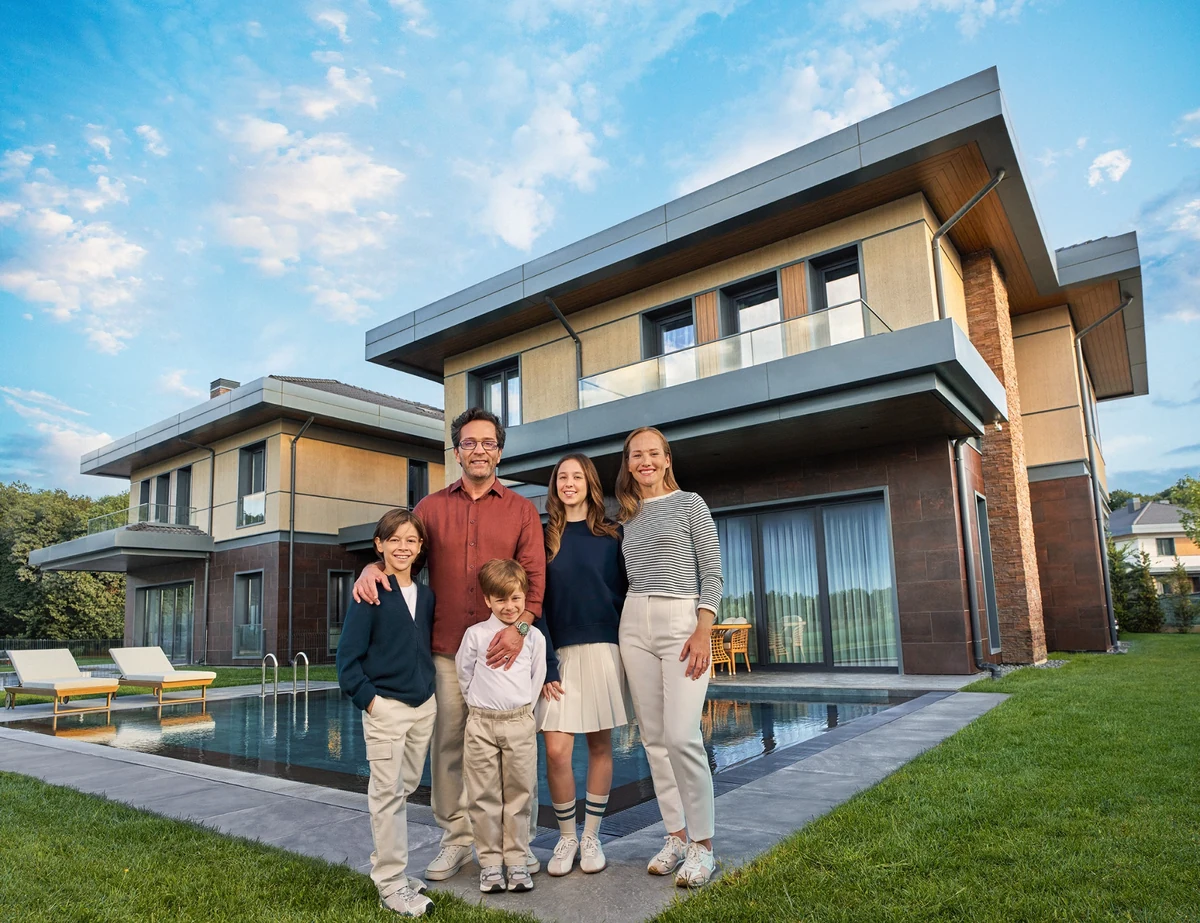 Geniş bir çimenlik alan ve özel yüzme havuzu bulunan modern villanın önünde, keyifli bir günün tadını çıkaran beş kişilik mutlu bir aile poz veriyor; bu manzara, slow living felsefesiyle şehirde iyi yaşam kurma arayışındaki aileler için Kasaba Modern'in sunduğu sakin ve doğayla iç içe yaşam biçimini gözler önüne seriyor.
