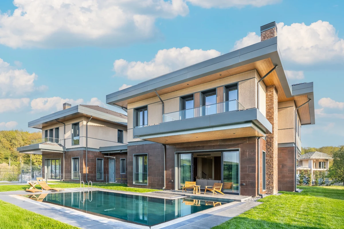 Geniş yeşil bahçesi ve yüzme havuzuyla donatılmış, modern mimarili bu villa, şehrin ortasında bile doğayla iç içe, huzurlu bir yavaş yaşam deneyimi sunarak makaledeki kavramları görselleştiriyor.
