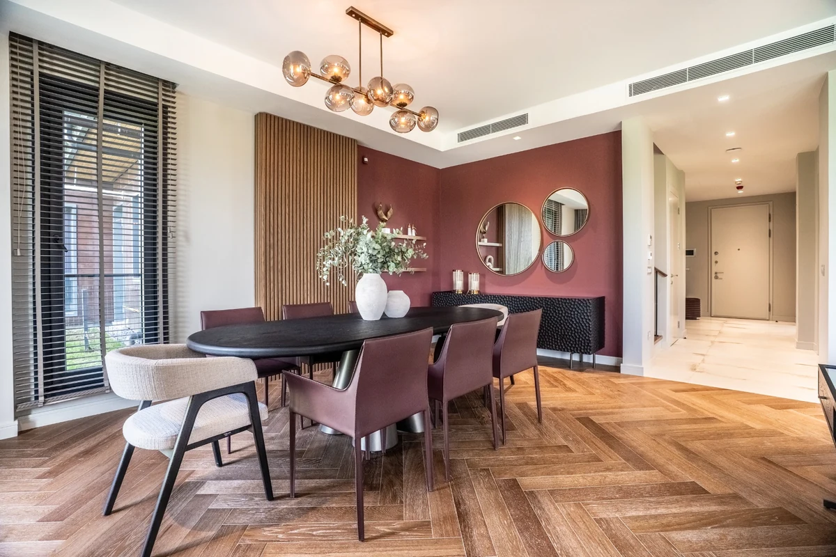 Kasaba Modern'deki geniş pencereli, herringbone parke zeminli, bordo duvarları ve modern avizesiyle dikkat çeken yemek alanı; oval siyah masası, bordo ve bej sandalyeleri, yeşilliklerle süslenmiş vazolarıyla şehirde slow living felsefesini destekleyen sakin ve dengeli bir iyi yaşam alanı sunuyor.