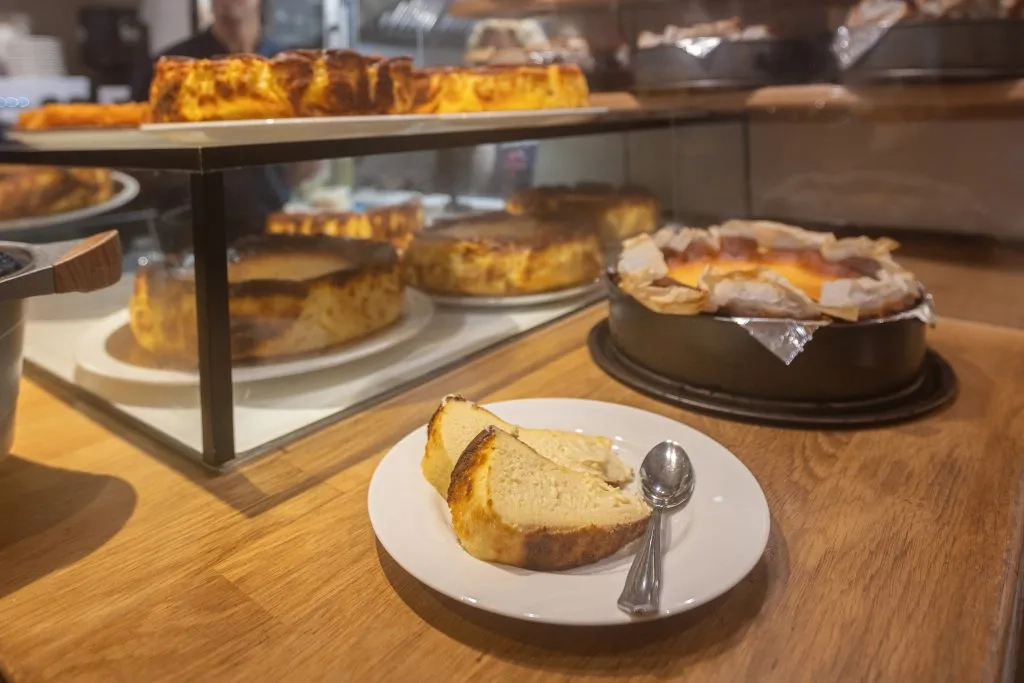 Yanık karamelize üst yüzeyi ve merkezindeki pürüzsüz, akışkan kremamsı iç dokusuyla iştah açan, meşhur İspanyol lezzeti San Sebastian cheesecake'in tek porsiyonluk enfes dilimi, makalenin San Sebastian cheesecake konusundaki içeriğini zenginleştiren çekici bir görsel sunuyor.