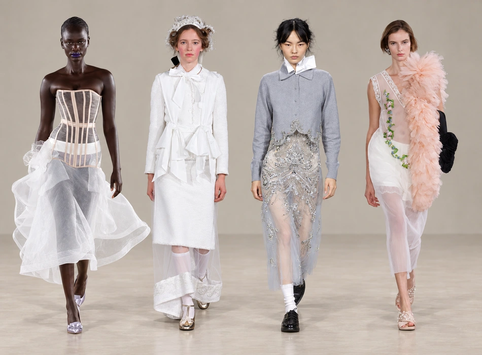 Londra Moda Haftası'nın dikkat çekici podyumunda, spot ışıkları altında zarifçe yürüyen bir model, modern ve minimalist çizgilerle tasarlanmış, transparan kumaşların cesurca kullanıldığı şık bir elbiseyi sunuyor.
