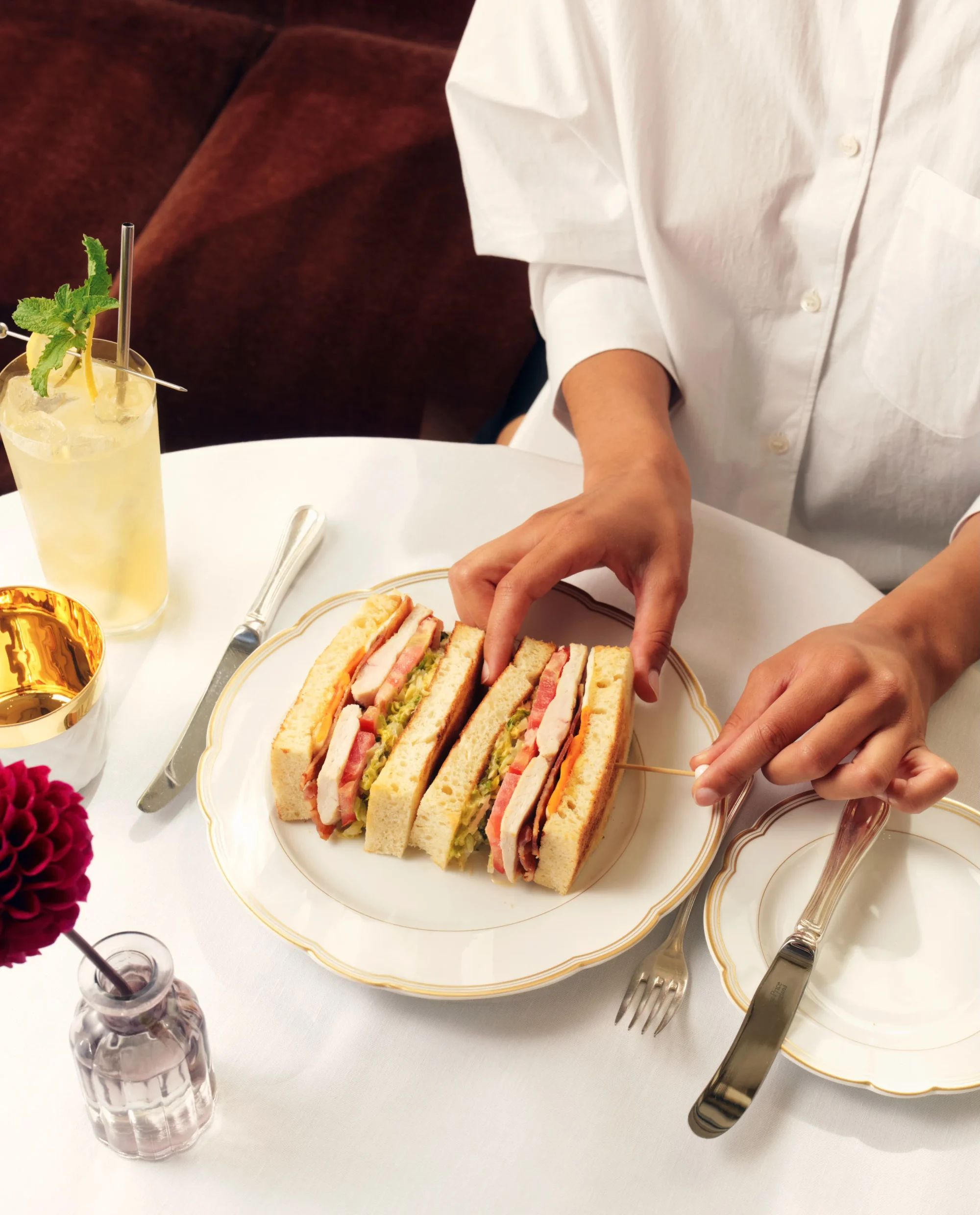 Kırmızı kapaklı açık bir Michelin Rehberi'ni nazikçe tutan bir el, sayfalarındaki özenle seçilmiş restoranlar ve mutfak deneyimleriyle ilgili detayları keşfederken, rehberin gastronomi dünyasına ışık tutan önemli bilgilerini vurguluyor.