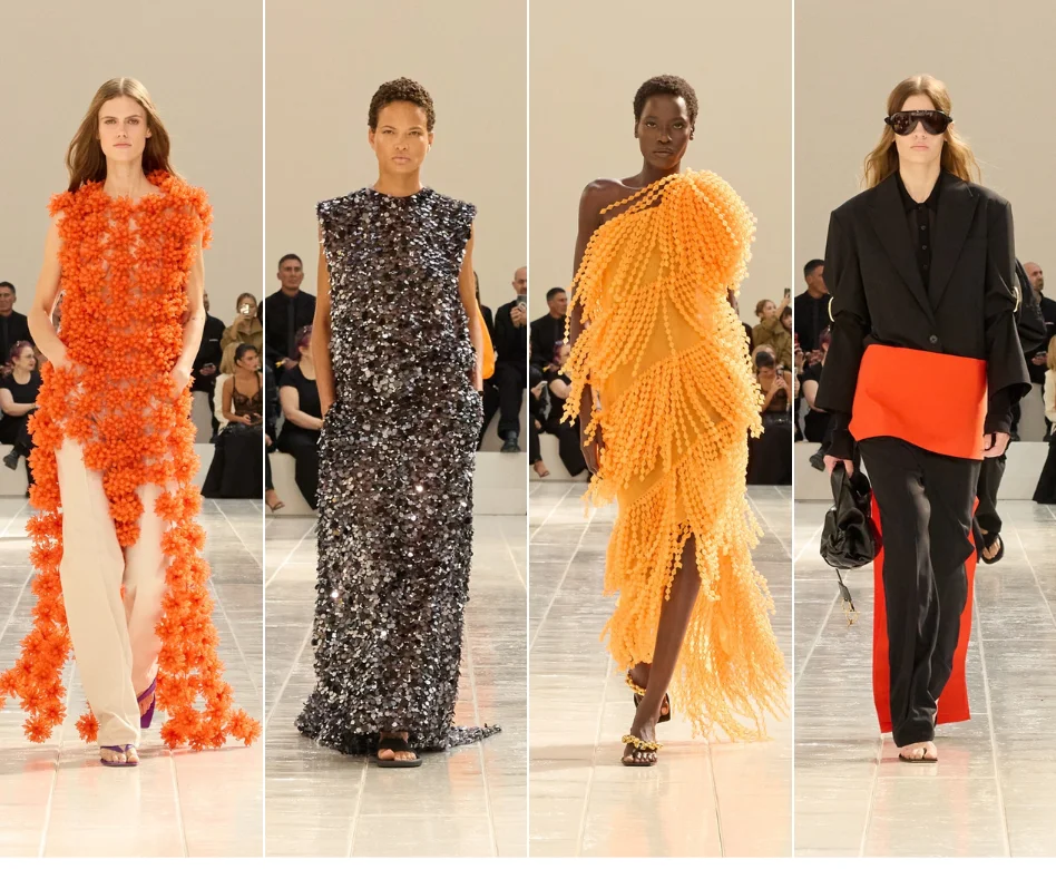 Paris Moda Haftası podyumunda, Balenciaga'nın güçlü ve mimari tasarım anlayışını yansıtan, omuzları abartılı ve modern kesimli koyu renk bir takım elbise giyen model, spot ışıkları altında kararlı adımlarla ilerlerken, defilenin dramatik atmosferi belirginleşiyor.