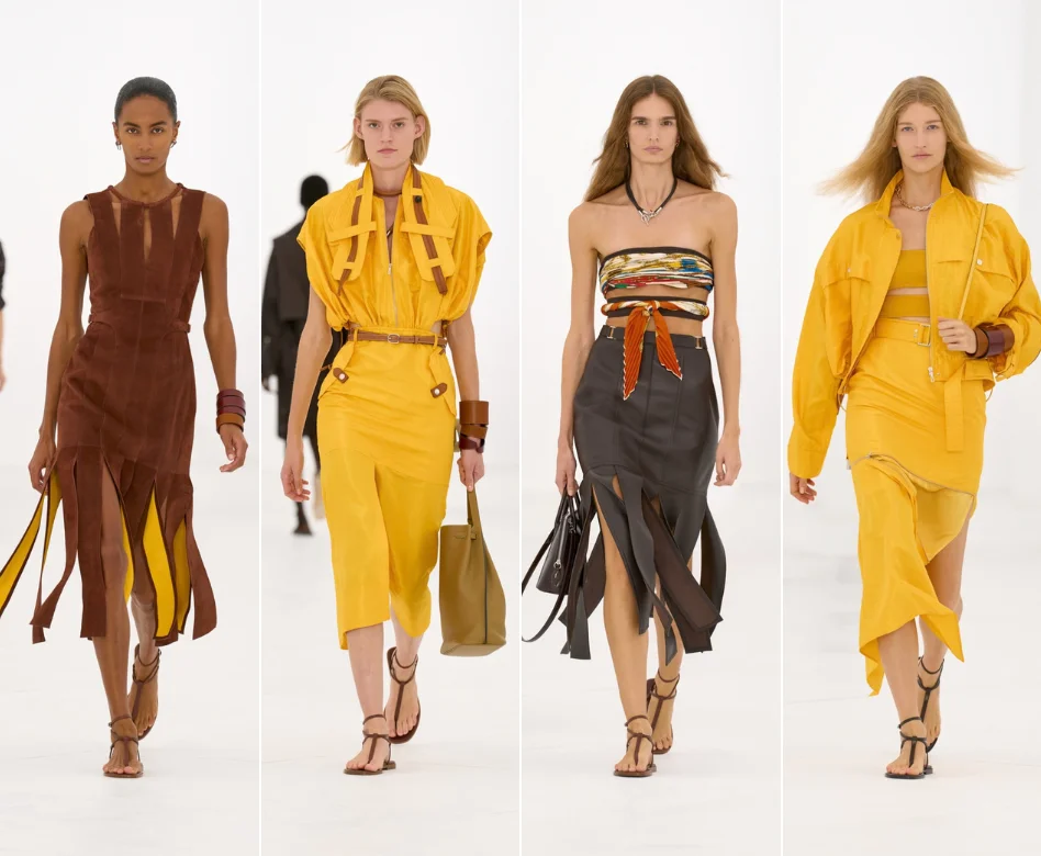 Hermès'in Paris Moda Haftası defilesinde podyumda yürüyen bir model, markanın zarafetini vurgulayan, sıcak bej tonlarında akıcı bir kesime sahip uzun bir palto ve rahat kesim bir pantolonla modern ve sofistike bir stil sergiliyor; loş ışıklar altındaki minimalist sahne tasarımı dikkat çekiyor.