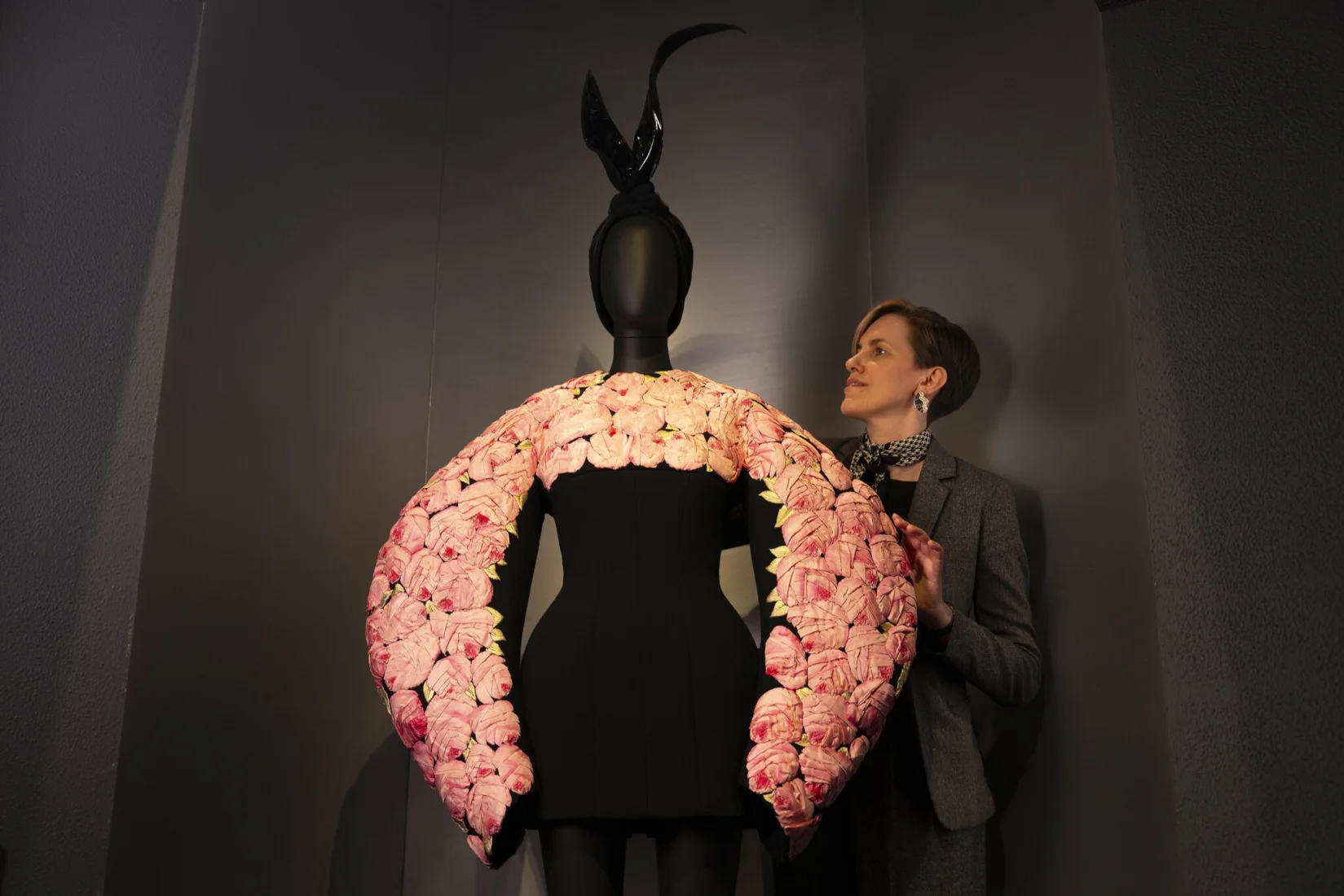 Schiaparelli sergisinden bir görünümde, markanın özgün ve avangart tarzını yansıtan, sürrealist esintili, cesur detaylara sahip bir moda tasarımı özel bir küratörlükle aydınlatılmış vitrinde sunuluyor, ziyaretçilerin dikkatini çekiyor.