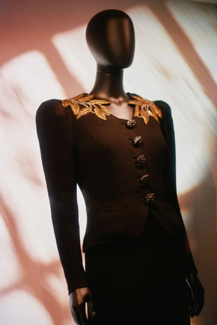 Schiaparelli'nin moda ve sanatı buluşturan vizyoner yaklaşımını sergileyen, heykelsi formlara ve sürrealist detaylara sahip bir haute couture tasarımı giyen mankenin profesyonel stüdyo çekimi.