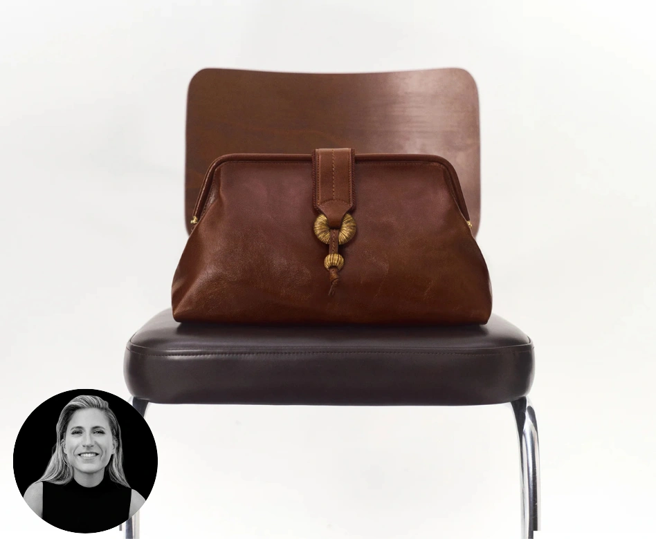Serena Uziyel markasına ait kahverengi deri clutch çanta, altın renkli halka ve boncuk detaylı eşsiz tokasıyla kahverengi bir sandalyede sergilenirken, sol alt köşede tasarımcı Serena Uziyel'in gülümseyen portresi yer alıyor.
