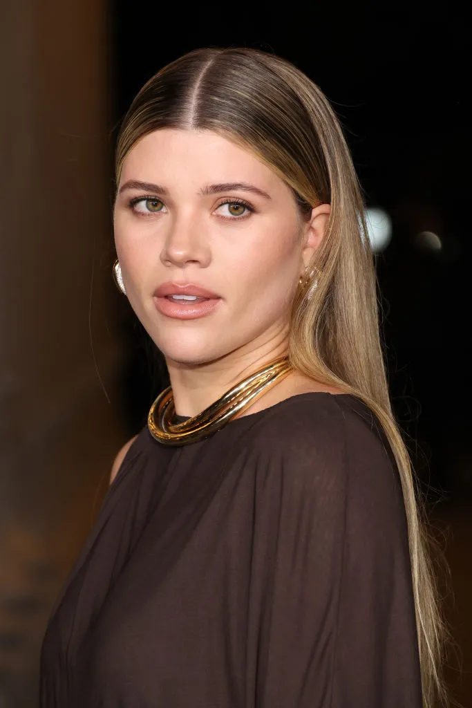 Açık renk saçları, sade makyajı ve zarif duruşuyla Sofia Richie, modern kesimli ve minimalist tonlardaki elbisesiyle doğal güzelliğini öne çıkarırken, sakin bakışlarıyla zahmetsiz şıklık akımının ikonik bir temsilcisi olarak dikkat çekiyor.