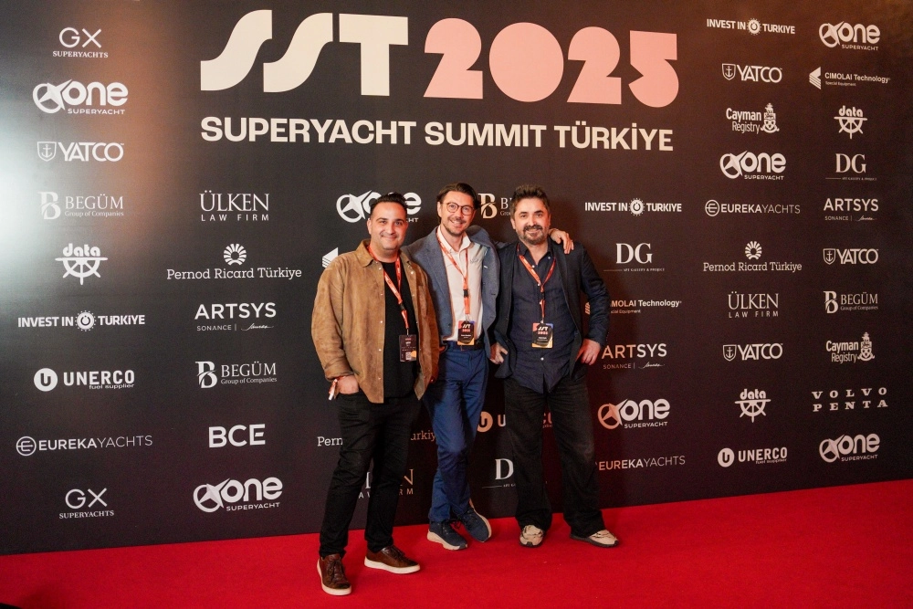 Türkiye'deki Süper Yat Zirvesi konferansında düzenlenen bir panel oturumunda, sahnedeki uzun bir masanın arkasında oturan konuşmacılar, mikrofonlara hitap ederek sektörün geleceğini ve yeniliklerini detaylıca ele alıyorlar.
