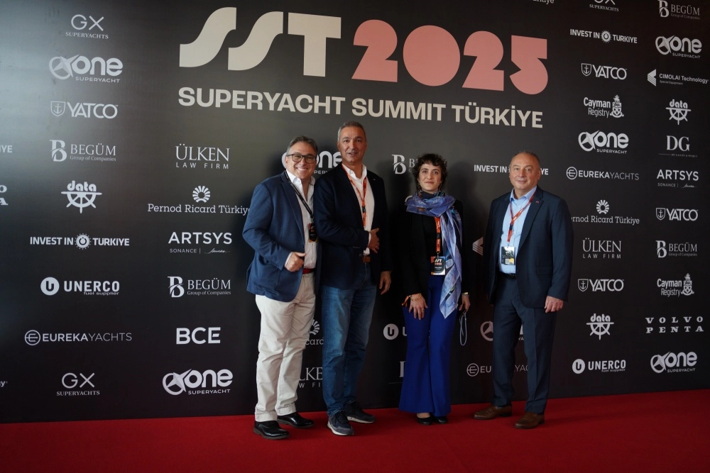 Super Yat Zirvesi Türkiye konferansında, sahnedeki uzun bir masanın arkasında oturan beş takım elbiseli erkek, önlerindeki mikrofonlarla etkinliğin gündemine ilişkin bir panel tartışması yapıyor.