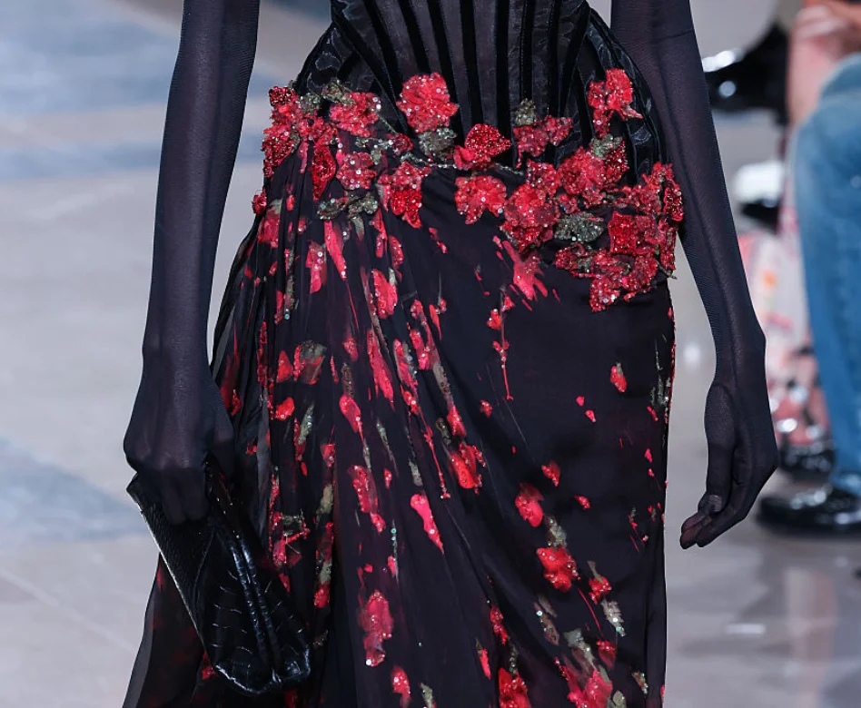 Podyumda yürüyen, el işi işlemelerle zenginleştirilmiş, akıcı kumaşlardan oluşan ve çağdaş haute couture estetiğini yansıtan bir gece elbisesiyle zarif bir model, 2027 moda haftası takvimi boyunca sergilenecek görkemli kreasyonların önizlemesini sunuyor.
