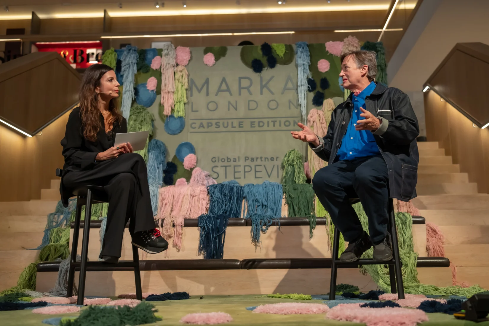 MARKA London konferansında sahnedeki panelde, endüstriyel tasarımcı Sebastian Conran'ın modern lüks ve insan merkezli tasarım üzerine ilham veren fikirlerini anlatırken, moderatör Çağdaş Ertuna'nın elinde mikrofonla dikkatle dinlediği bir an.