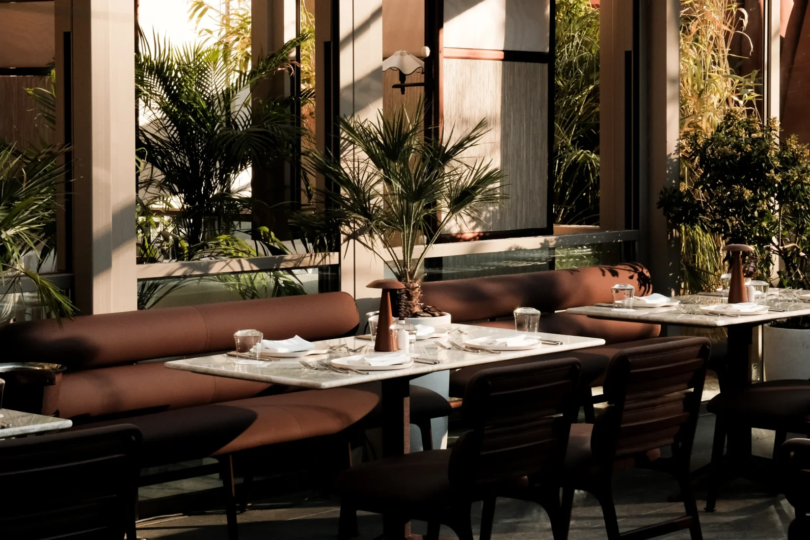 Scalla restoranının geniş pencerelerinden süzülen güneş ışıklarıyla aydınlanan, kahverengi rahat banketler ve modern sandalyelerle düzenlenmiş, yeşil bitkilerle çevrili şık yemek alanında, Akdeniz esintileri taşıyan yeni mutfağın davetkar atmosferi hissediliyor.