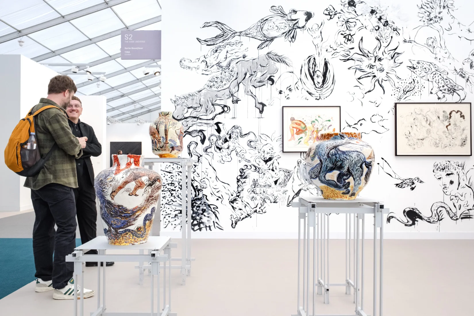 Frieze London'daki The Code Universe bölümünde, göstergebilimden ilham alan popüler kültür kodlarını ve insan algısını sorgulayan bir çalışma kapsamında, başını ve üst bedenini saran, doğal liflerden örülmüş gibi duran heykelsi bir kostüm giyen kişi görünüyor.