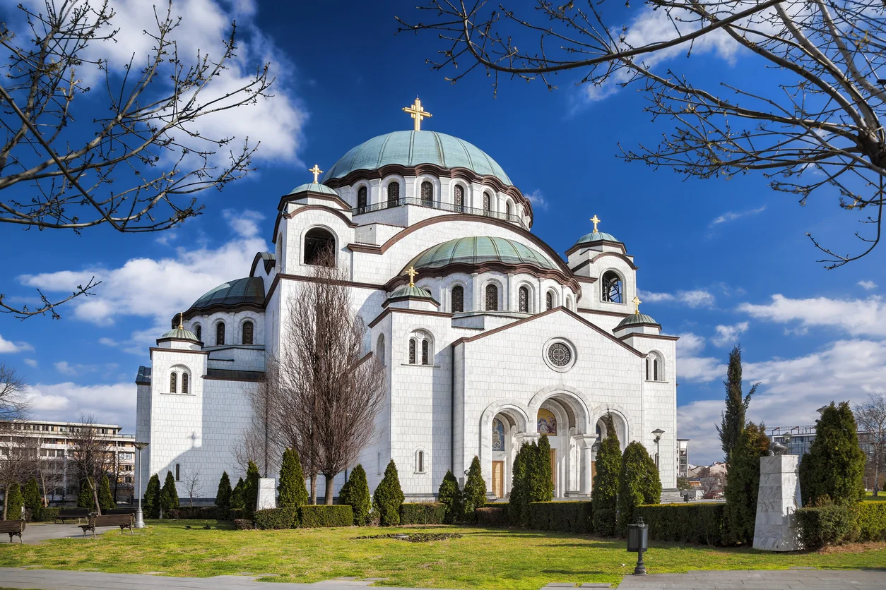 Belgrad silüetine heybetli bir şekilde yükselen, devasa kubbeli Aziz Sava Katedrali, beyaz taş cephesi, karakteristik yeşil çatıları ve altın haçlarıyla Bizans mimarisinin modern bir yorumunu sunarak şehrin en ikonik yapılarından biri olarak dikkat çekiyor.