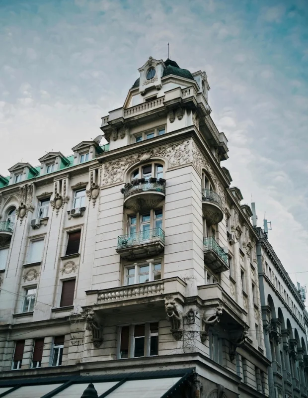 Belgrad'daki Saint Ten Hotel'in lüks lobisi, yüksek tavanları, bol doğal ışık alan büyük pencereleri ve modern dokunuşlarla harmanlanmış klasik şık mobilya takımlarıyla misafirlerine konforlu ve prestijli bir karşılama sunuyor.