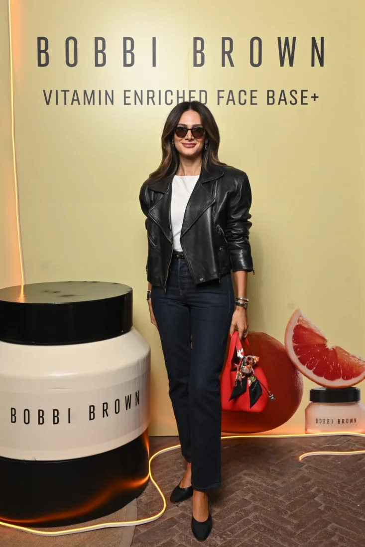 Kısa koyu saçlı, sıcak bir gülümsemeyle bakan ve sol elini kaldırarak konuşurken samimiyetini yansıtan deneyimli makyaj sanatçısı Bobbi Brown; bu canlı portre, onun doğal güzellik anlayışını ve ilham veren başarı hikayesini okuyuculara aktarıyor.