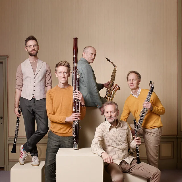 Cemal Reşit Rey Konser Salonu sahnesinde, farklı nefesli çalgıları ustalıkla icra eden Calefax Beşlisi'nin beş müzisyeni, parlak sahne ışıkları altında dinamik bir konser performansı sergilerken, bu sanatsal sunumun yoğun enerjisi ve enstrümanların görsel harmonisi dikkat çekiyor.