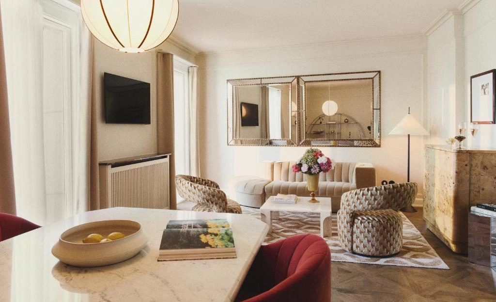 Hotel Bella Grande'nin zarif restoranında, özenle dizilmiş birden fazla tabak, parlak çatal bıçak takımları, şarap kadehleri ve taze beyaz güllerle bezenmiş bir masanın yakın çekimi, otelin misafirlerine sunduğu lüks ve kaliteli yemek deneyimini vurguluyor.
