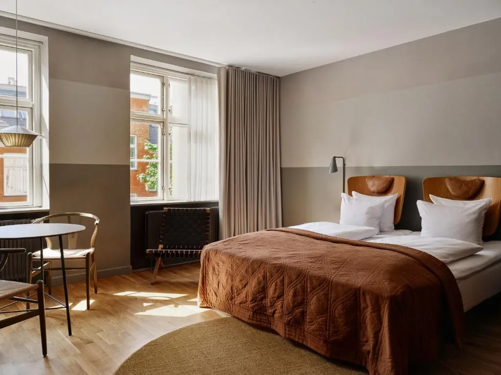 Hotel SP34'ün geniş ve şık bir şekilde dekore edilmiş lobisi, modern tasarım anlayışını yansıtan rahat koltuk takımları, göz alıcı aydınlatma elemanları ve doğal ahşap dokunuşlarıyla ziyaretçilere huzurlu ve konforlu bir konaklama başlangıcı sunuyor.