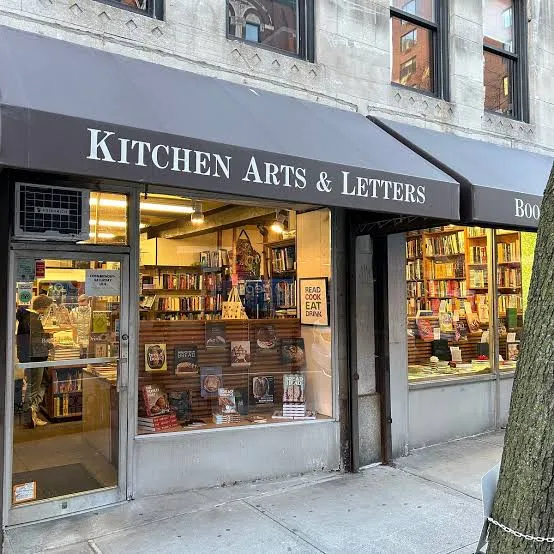 New York'taki ünlü gastronomik kitapçı Kitchen Arts & Letters'ın dış cephesi, geniş vitrininde sergilenen çeşitli yemek kitapları, gastronomi yayınları ve içeriği dolduran raflarıyla makalenin konusunu oluşturan dünyanın en özel gastronomi kitapçıları arasında öne çıkıyor.