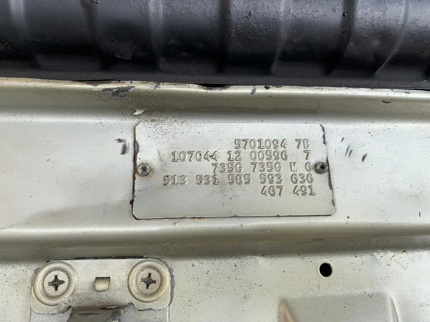 Parlak krom detaylarıyla öne çıkan, büyük bir titizlikle cilalanan ve özenle bakılan koyu renkli bir klasik otomobilin far çevresindeki parlak metal aksamını bir kişinin bej renkli bir bezle dikkatlice temizlemesi, aracın yüksek değerini ve özel bakım gereksinimini vurguluyor.