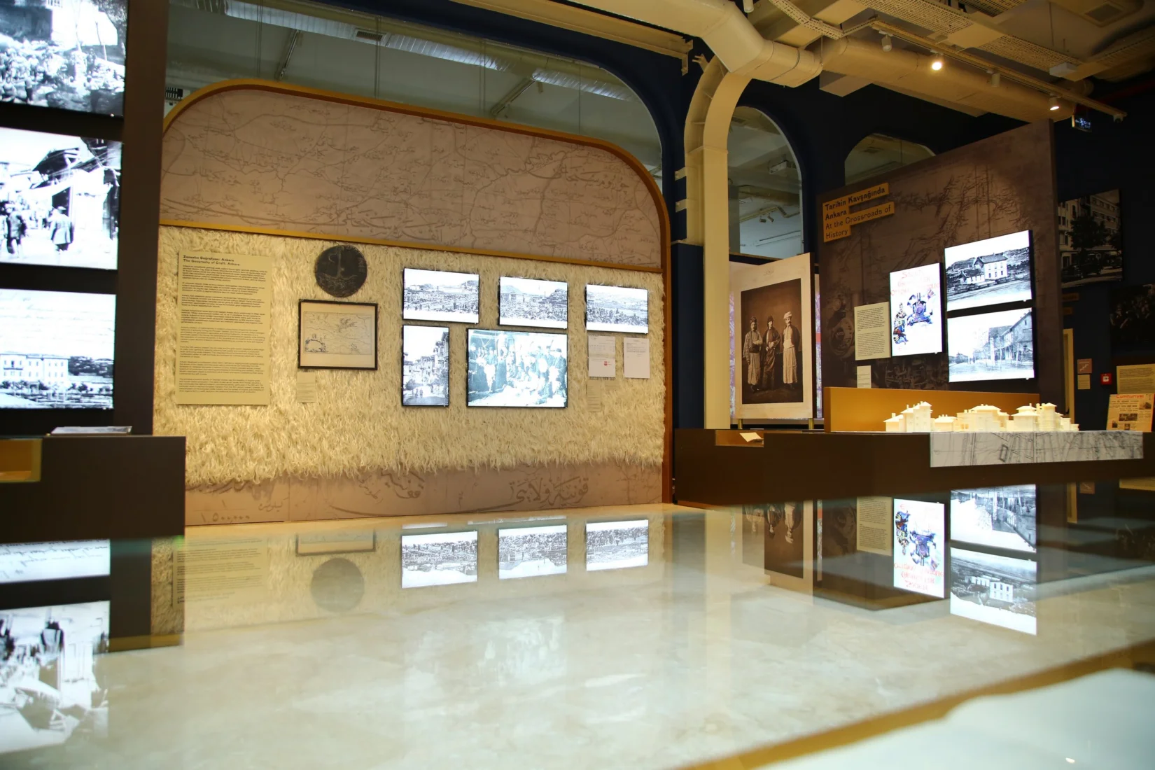 Koç sergisinin genel bir görünümünü yansıtan bu fotoğrafta, sanatseverlerin çeşitli modern sanat eserleri ve heykellerin özenle sergilendiği geniş, ferah bir salonda ilgiyle dolaştığı anlar kaydedilmiş.