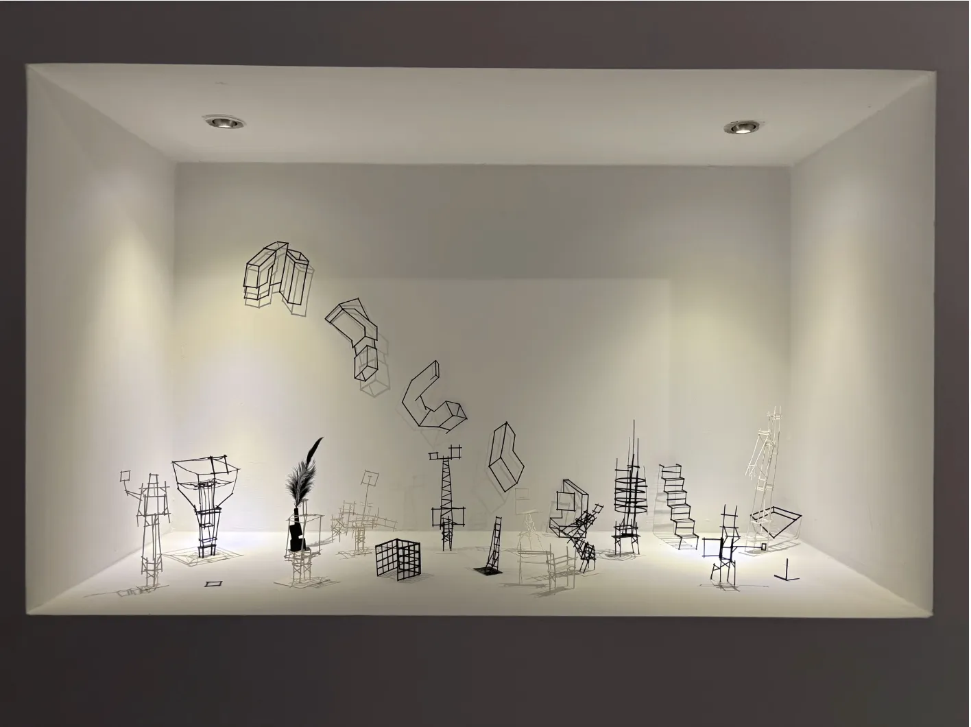 Nermin Er'in Galeri Nev Ankara'daki sergisinden bir karede, beyaz duvarlı modern bir galerinin iç mekanında, sol tarafta toprak tonlarında dokulu büyük soyut bir eser ile sağda çeşitli boyutlarda diğer çağdaş sanat çalışmalarının sergilendiği, yumuşak ışıkla aydınlatılmış bir görünüm.