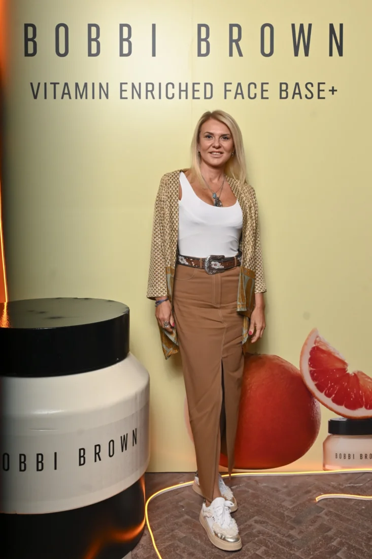 Bobbi Brown markasına ait çeşitli makyaj ürünlerinin, özenle düzenlenmiş ve doğal ışıkla aydınlatılmış bir stüdyo ortamında estetik bir kompozisyon oluşturarak markanın zarafetini vurguladığı bir görsel.