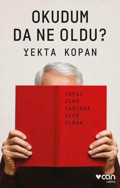 Uzun koyu renk saçlı, gözlüklü bir kadın, çalışma masasında ellerini dayadığı açık bir kitaba veya dijital ekrana yoğunlaşmış, okudum da ne oldu sorusunun ağırlığını hissettiren, derin düşünceli bir anı yansıtıyor.