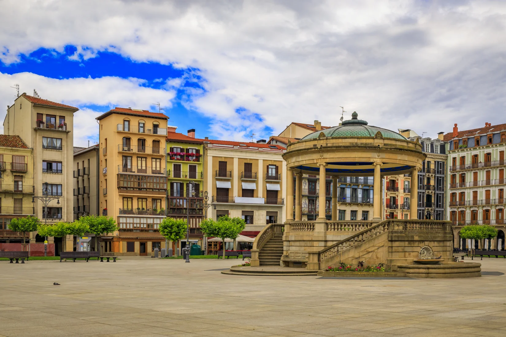 Pamplona'nın tarihi sokaklarında, geleneksel beyaz giysileri ve kırmızı fularlarıyla toplanmış coşkulu kalabalık, San Fermín Festivali'nin simgesi olan boğa koşusu öncesindeki heyecanlı bekleyişi gözler önüne seriyor, İspanya'nın bu eşsiz şenliğinin canlı atmosferini yansıtıyor.