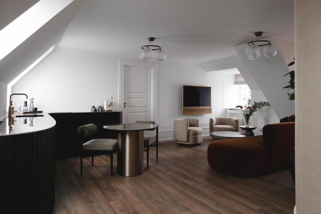 Kopenhag’ın lüks otellerinden Park Lane Copenhagen’da bulunan, ahşap zeminli, modern ve şık İskandinav tasarımına sahip, mini barı, yemek masası, konforlu oturma grubu ve duvara monte televizyonuyla aydınlık bir çatı katı süiti.