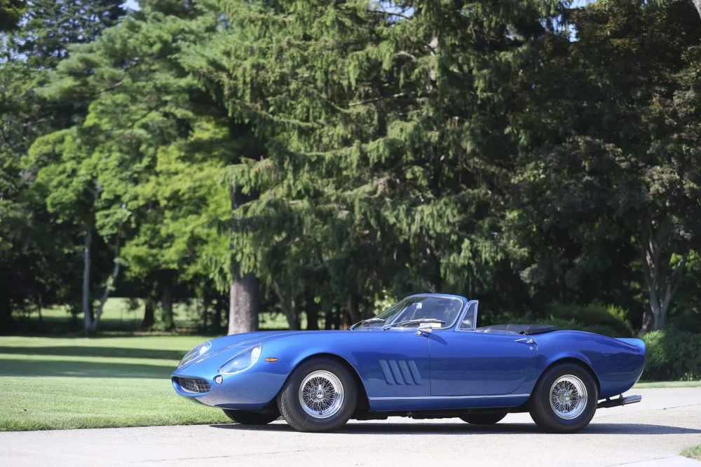 Steve McQueen'in eşsiz zevkini yansıtan, güneşte parlayan mavi rengiyle göz kamaştıran, nadir ve ikonik bir klasik olan Ferrari 275 GTB NART Spider cabrio otomobil, detaylı bir şekilde sergileniyor.